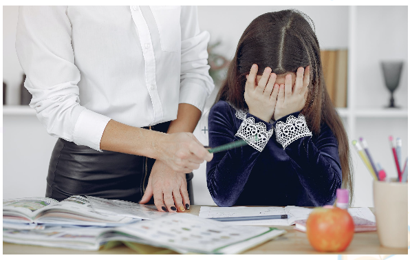 03 Person resting hands on forehead while looking at papers spread on a table
